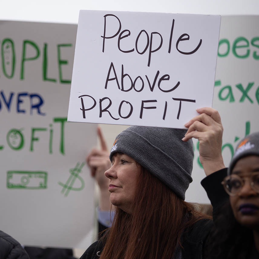 A protester holds a sign that reads "People Above Profit" at a rally in front of the U.S. Supreme Court.